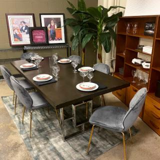 A stylish dining area featuring a modern table set for dinner, complemented by decorative art and indoor plants.