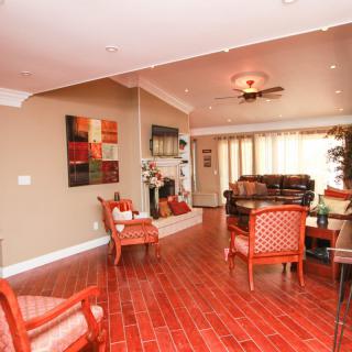 A warm and inviting living room with wooden floors, comfortable seating, and colorful artwork.