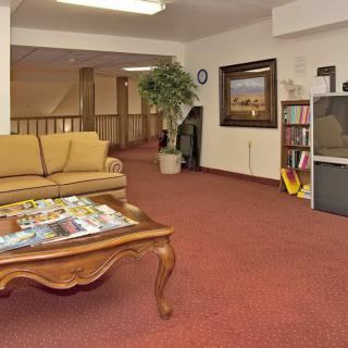 A cozy waiting room with a sofa, coffee table, and various reading materials.