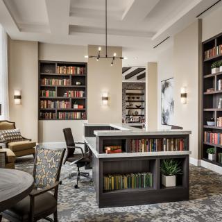 A modern library interior with bookshelves, comfortable seating, and ample lighting.