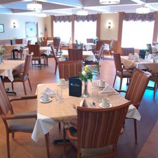 A neatly arranged dining room with tables and chairs set for service.