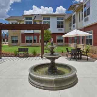 A serene courtyard featuring a fountain and comfortable outdoor seating for relaxation.