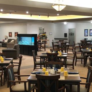 An inviting restaurant dining area with neatly arranged tables and an aquarium centerpiece.