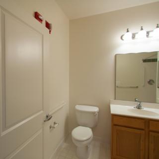 A simple bathroom with a toilet, sink, and mirror.