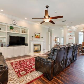 A cozy living room featuring leather recliners, a large television, and a fireplace.