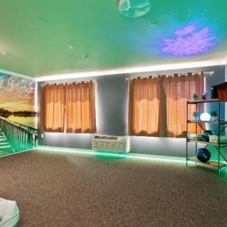 A modern room with LED lighting and large windows covered by curtains.