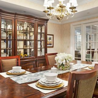 Elegant dining room with a set table, a chandelier, and a china cabinet.