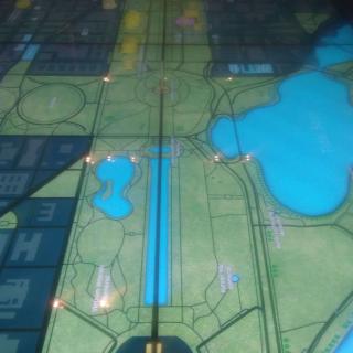 A floor map depicting an urban area with pathways, bodies of water, and architectural layouts.