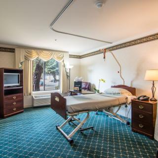A spacious hospital room with a medical bed and furniture, designed for patient care.