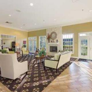A spacious and elegantly furnished living room with large windows and a fireplace.