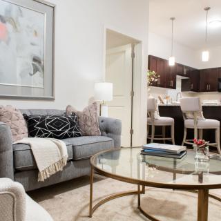 A cozy living room with a comfortable sofa, stylish coffee table, and view into the kitchen area.
