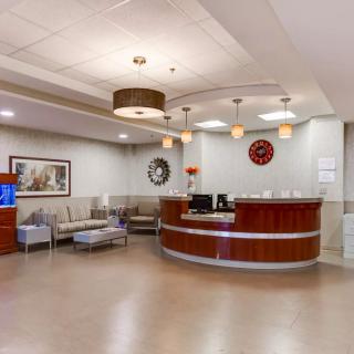 A modern reception area with a circular desk and comfortable seating in the waiting room.