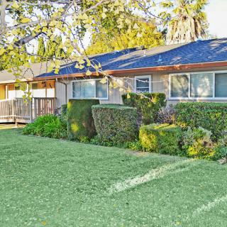 A suburban home with a well-maintained lawn and neatly trimmed bushes.