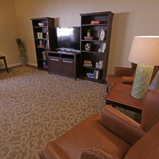 A cozy living room with bookshelves, a television, and comfortable seating.