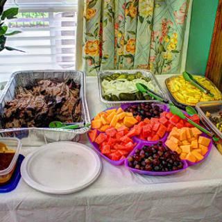 A colorful spread of delicious food featuring a variety of fruits and savory meats, perfect for a gathering.