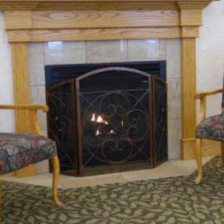 A cozy living room setup with a fireplace flanked by two comfortable chairs.