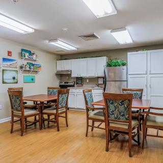 A cozy dining and kitchen area with tables, chairs, and modern amenities.