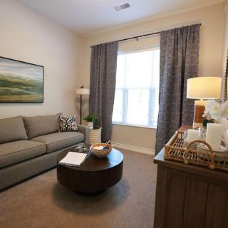 A cozy living room with a comfortable sofa, round coffee table, and decorative elements such as artwork and lamps.