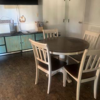 A kitchen dining area with a round table and four chairs.