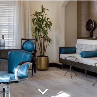 A modern office space featuring stylish blue chairs, a potted plant, and a sleek seating area.