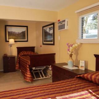 A cozy bedroom with twin beds, decorated with striped bedding and landscape wall art.