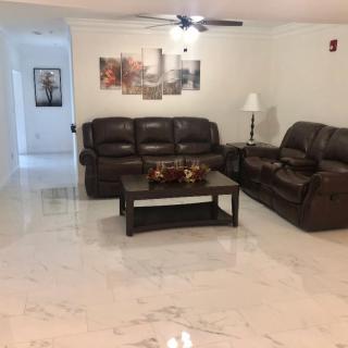 A cozy living room with leather sofas and a coffee table on a tiled floor.