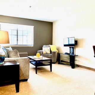 A cozy living room with comfortable seating, a television, and ample natural light.