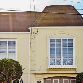 A residential house with a sloped roof and large windows above a garage.