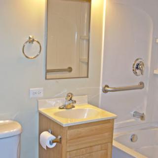 A clean and simple bathroom setup featuring a sink, toilet, bathtub, and mirror.