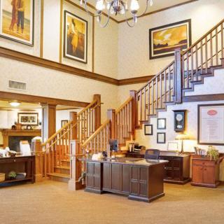 A welcoming lobby area featuring wooden stairs and decorative artwork on the walls.