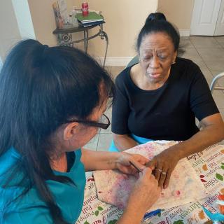 A woman receives a manicure at home, focusing on self-care and well-being.