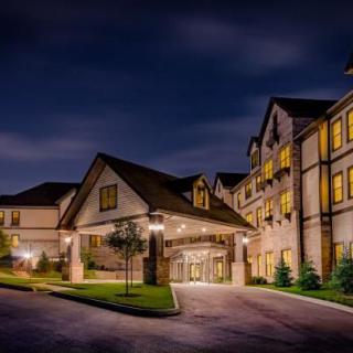 A well-lit building exterior at night with landscaped surroundings.