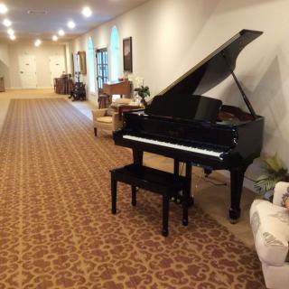 A spacious hallway with a grand piano and elegant decor.