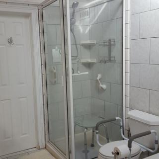 A modern bathroom with a glass-enclosed shower, toilet, and sink.