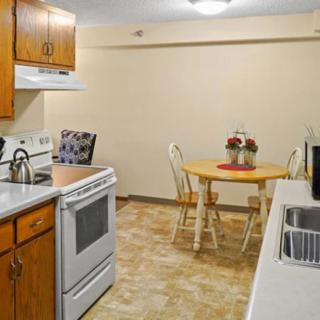 A cozy kitchen with wooden cabinets and a small dining area.