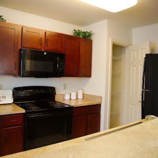 A modern kitchen featuring black appliances and wooden cabinets.