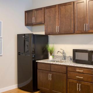 Modern kitchen with wooden cabinets and essential appliances.