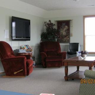 A cozy living room with armchairs, a television, and a coffee table.