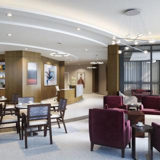 A modern lounge with comfortable seating and a reception desk.