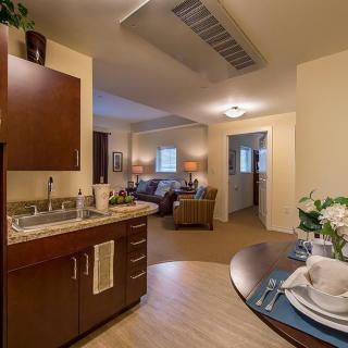A cozy and well-furnished apartment interior featuring a kitchenette and living room.
