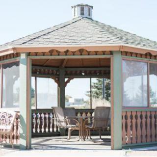 A charming gazebo featuring comfortable seating, perfect for enjoying the outdoors.