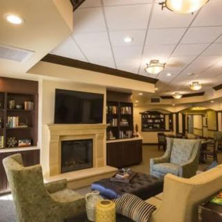 A cozy living room with comfortable seating, a fireplace, and bookshelves.
