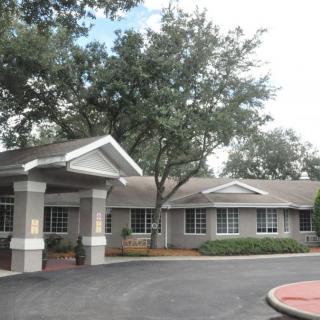 A suburban residential building with a driveway and trees.