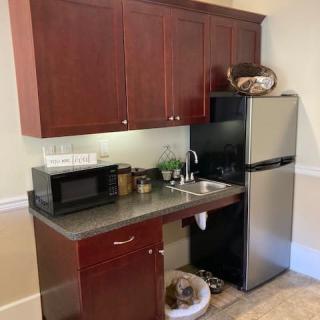 A small kitchenette with cabinets, a microwave, and a refrigerator.