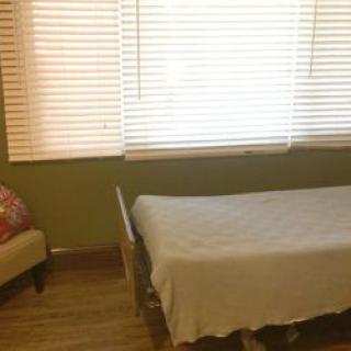 A minimalist bedroom with a single bed and window blinds.