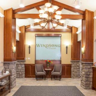 A well-decorated lobby featuring wooden beams, a chandelier, and a cozy seating area.