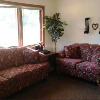 Cozy living room with floral sofas and natural light.