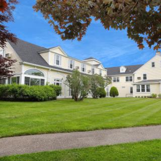 A beautiful residential home with a well-maintained lawn and clear blue skies.