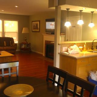 A cozy open-plan living area with a kitchen, dining table, and comfortable seating.