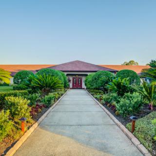 A welcoming entrance surrounded by lush greenery and a well-maintained pathway.